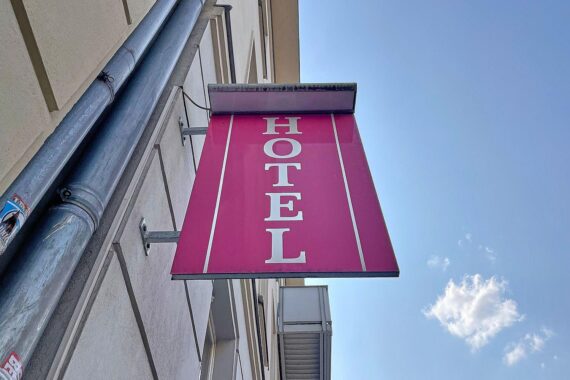 Beherbergungsbetrieb mit internationalen Gästen, symbolisiert durch ein einladendes Hotel und Reisende.