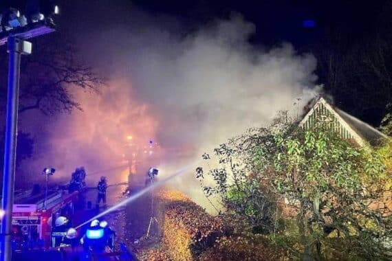 Reetdachhaus in Kehdingbruch brennt vollständig nieder, Feuerwehr kämpft gegen verheerende Flammen.