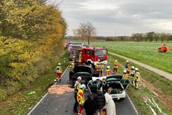 Rettungshubschrauber über Unfallstelle, Feuerwehr im Einsatz, verletzte Personen und Unfallfahrzeuge sichtbar.