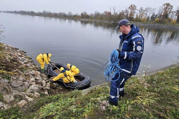 THW-Einsatz: Ehrenamtliche im Schlauchboot bergen tote Vögel, Schutzkleidung getragen, um Vogelgrippe zu bekämpfen.