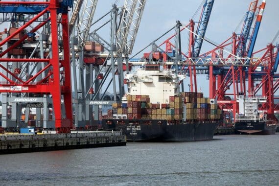 Containerschiff transportiert Waren; symbolisiert steigende Großhandelspreise und globalen Handel.