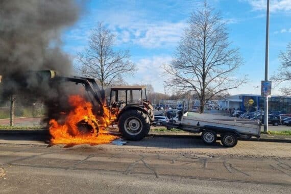 Traktor in Flammen auf Lindenstraße, Feuerwehr löscht, Fahrbahn gesperrt, Fahrer unverletzt.