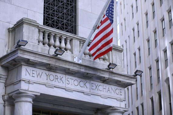 US-Fahne weht an der New York Stock Exchange, Börsenkurs mit deutlichen Minuszeichen.