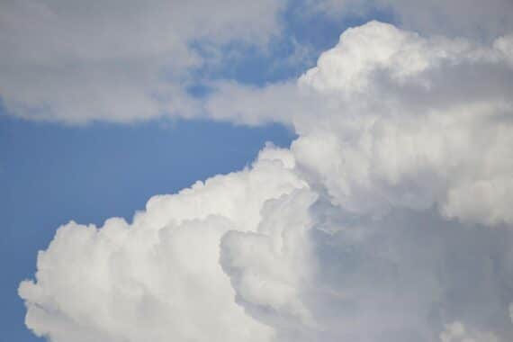 Dunkle Wolken über verschneiten Landschaften, symbolisieren Kälte und glatte Straßen in Baden-Württemberg.