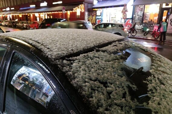 Schnee auf einem Autodach unter winterlichem Himmel mit frostigen Temperaturen und glatten Straßen.