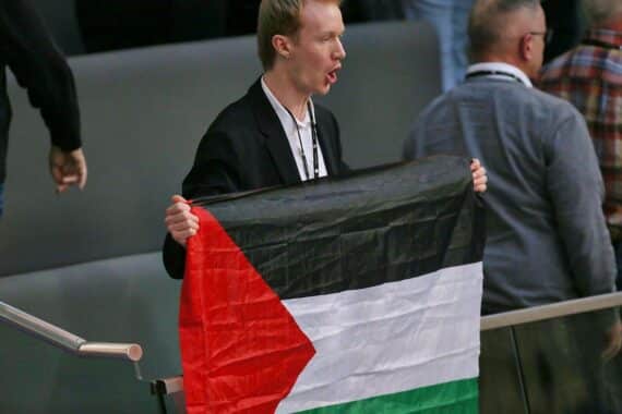 Protest im Bundestag: Besucher mit Palästinenserfahne stört Sitzung, kritische Ausdrucksform gegen Krieg.