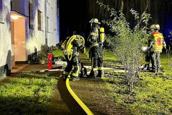 Feuerwehr und Rettungsdienst vor einem Wohngebäude nach Brandlöschung durch Bewohner.