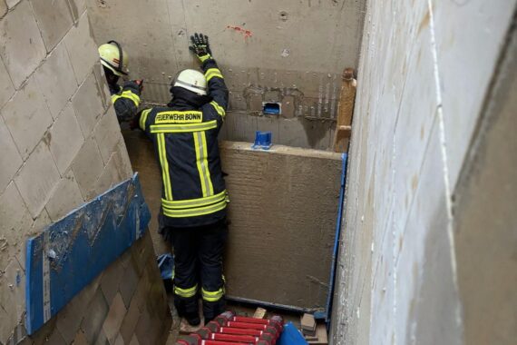 Rettungskräfte befreien eingeklemmte Bauarbeiter unter eingestürzter Betontreppe in Bonn-Beuel.