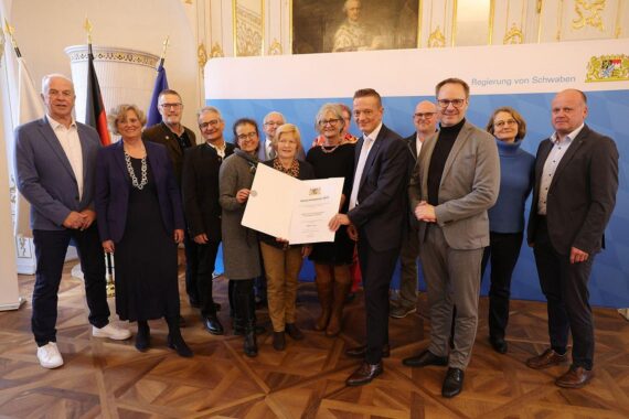 Zwei Preisträger erhalten Integrationspreise vor Publikum in festlicher Atmosphäre.