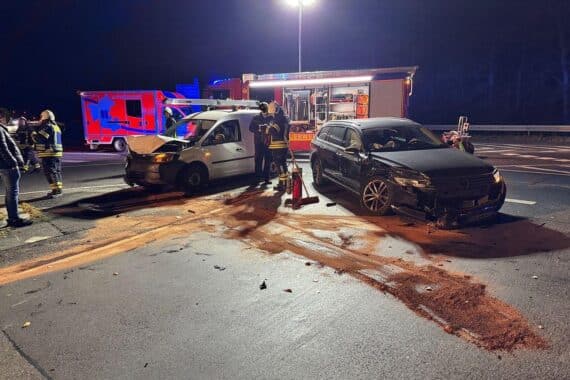 Zwei beschädigte Pkw und Feuerwehrkräfte sichern Unfallstelle im Autobahnkreuz Wuppertal Nord.