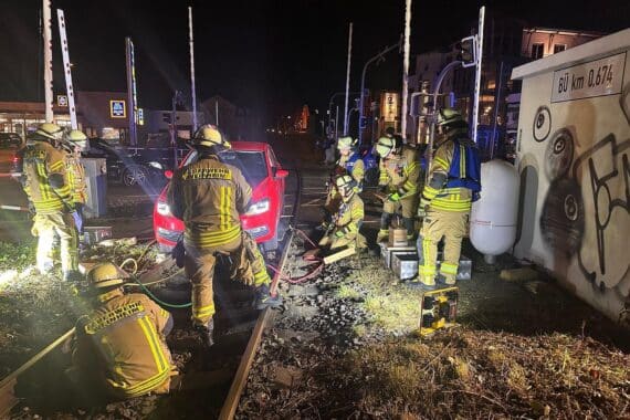 Auto auf Gleisen, Feuerwehr bei Bergung, Bahnverkehr unterbrochen, Dunkelheit, kleine Schäden, Fahrerin unverletzt.
