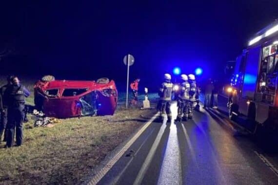Unfallstelle mit überschlagenem Nissan Micra und Polizeiabsperrung, Schäden sichtbar.
