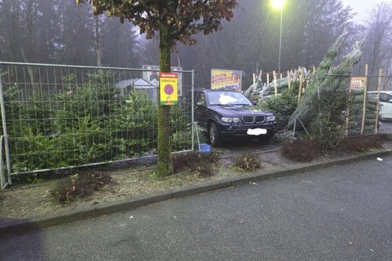 Unfall auf Parkplatz: BMW beschädigt Weihnachtsbaumverkaufsstand, glücklicherweise ohne Verletzte.
