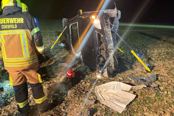 Feuerwehr befreit Fahrer nach Unfall; Auto im Gleisbett und Feld, Rettungsdienst vor Ort.