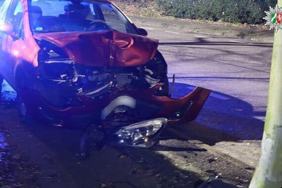 Autounfall: Roter Opel Corsa kollidiert mit Laterne, Totalschaden, verletzt Fahrerin.