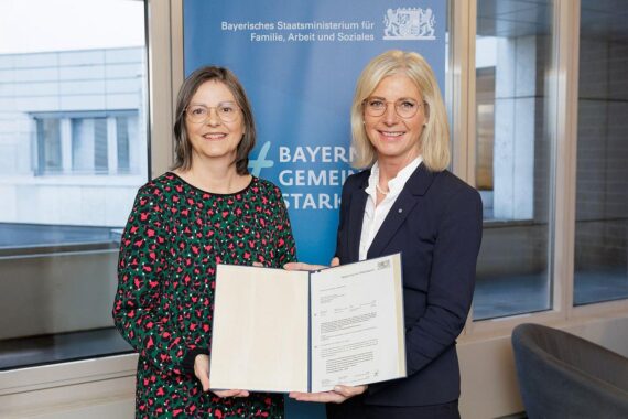 Ulrike Scharf übergibt Förderbescheid an Prof. Dr. Mützel für Kinderschutzambulanz in Bayern.