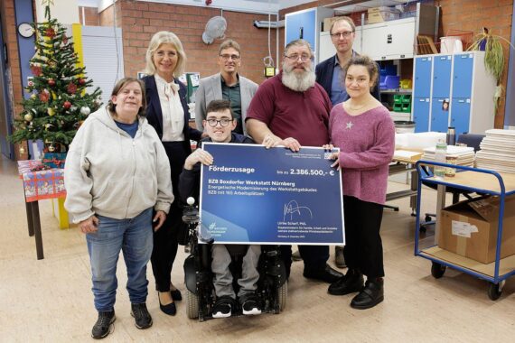 Ulrike Scharf übergibt Förderscheck zur Modernisierung der Boxdorfer Werkstatt in Nürnberg.