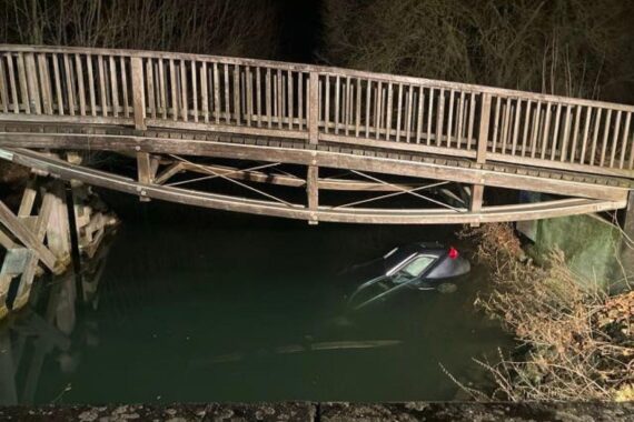 Unfallfahrzeug im Staubecken, Polizei und Feuerwehr bei Bergungsarbeiten, winterliche Straßenverhältnisse.