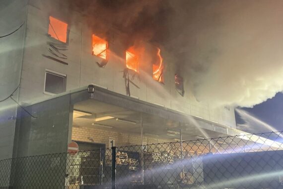 Ein brennendes Bürogebäude in Hattersheim mit Feuerwehr und Rauchentwicklung bei Nacht.
