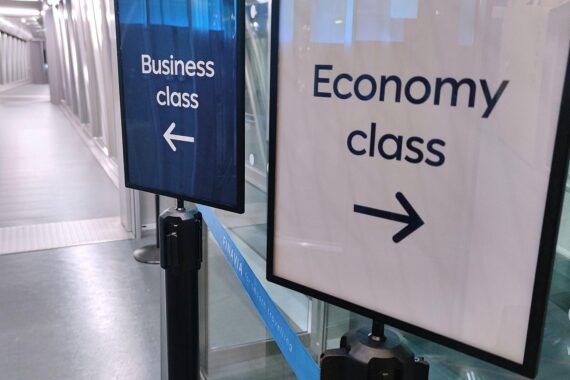 Wegweiser zeigt klare Unterscheidung zwischen Business Class und Economy Class für Bundestagsabgeordnete.