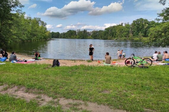 Sonniger Badestrand mit Menschen, symbolisiert die Wärme und Trockenheit des Jahres 2025.