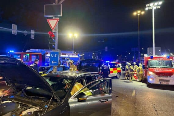 Verkehrsunfall an Kreuzung mit drei beschädigten Fahrzeugen, Rettungs- und Feuerwehreinsatz sichtbar.