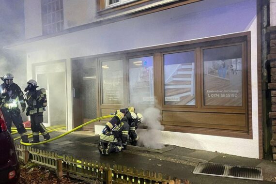 Feuerwehr im Einsatz: Löschangriff am Wohn- und Geschäftshaus bei Rauchentwicklung aus Keller.