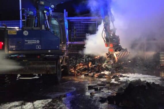 Feuerwehr löscht Brand in Wittenberg: Einsatzkräfte vor Rauchentwicklung und Lagergebäuden.