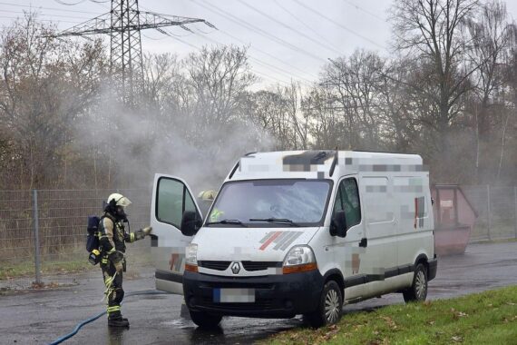 Feuerwehr löscht brennenden Kleinbus, Einsatzkräfte sichern die Stelle, Brandbekämpfung in Hünxe.