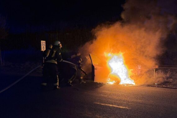 Brennender Pkw mit Feuerwehr im Einsatz, nachts in Bergen, Landkreis Celle.