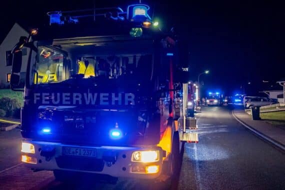Feuerwehr löscht Mülltonnenbrand; Bewohner verletzt, Kellerfenster geplatzt, Rauchentwicklung.