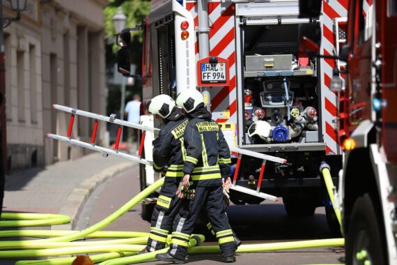 Feuerwehr rettet Frau nach Wohnungsbrand in Berlin, Ursache vermutlich Zigarettenkippe.