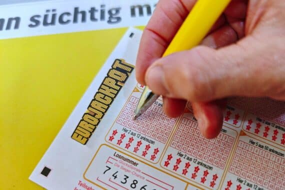 Ein Eurojackpot-Spielschein mit Gewinnzahlen, umgeben von Glücksspiel-Elementen und einem europäischen Hintergrund.