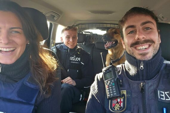 Hund im Polizeistreifenwagen, sicher nach Autobahn-Einsatz, zeigt Verantwortung von Verkehrsteilnehmern.