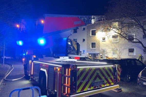 Einsatzkräfte löschen Kellerbrand in Mehrfamilienhaus, Bewohner evakuiert, Feuerwehr in Aktion.