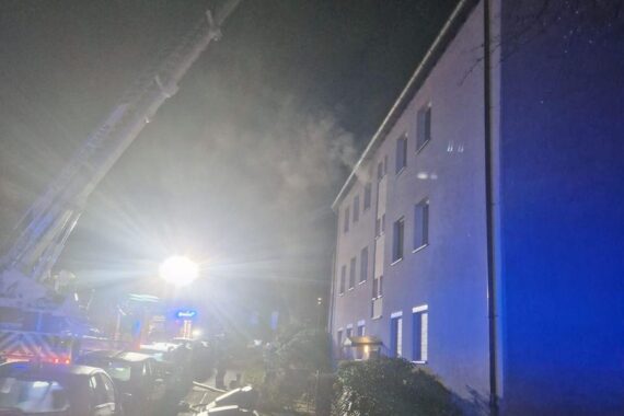 Feuerwehr kontrolliert Dach mit Teleskopmast nach Küchenbrand in Mehrparteienhaus in Haan.