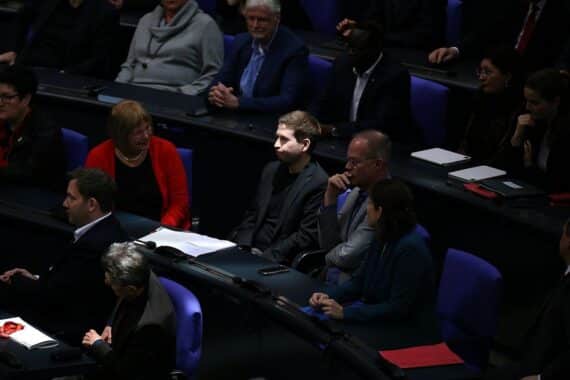 Kevin Kühnert lächelt nachdenklich in einem Interview, reflektierend über seine politische Vergangenheit.