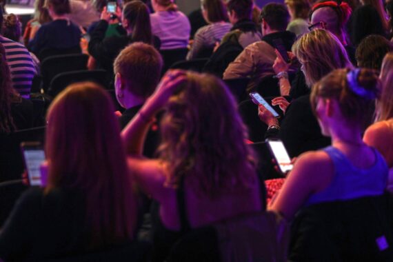 Junge Menschen interagieren mit Smartphones, symbolisieren digitale Medienkompetenz und Vernetzung in der Bildung.