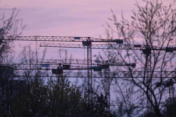 Baukräne auf einer Baustelle symbolisieren den Ausbau von sozialem Wohnraum in Schleswig-Holstein.