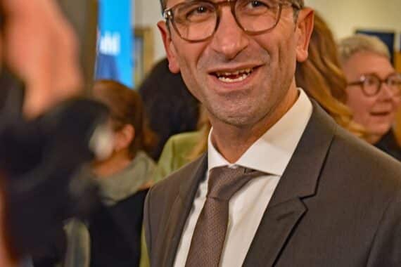 Samet Yilmaz feiert seinen Sieg als Oberbürgermeister von Kiel, umgeben von Unterstützern.