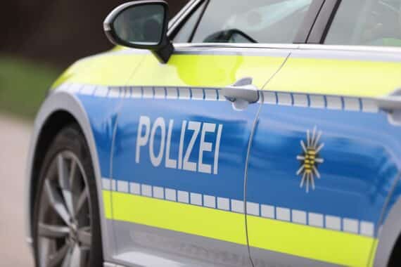 Unfallstelle mit Polizeiauto, beschädigten Anhängern und Weizen auf der Bundesstraße 9.