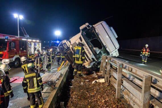Schwerer LKW-Unfall auf Autobahn, Feuerwehr rettet eingeklemmten Fahrer, Verkehr beeinträchtigt.