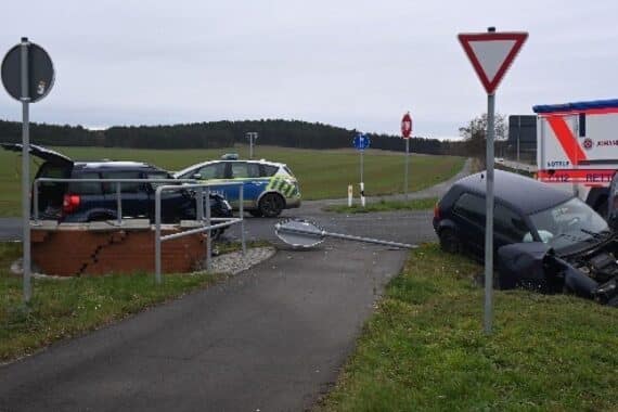 Zwei beschädigte Autos nach Unfall, Polizei vor Ort, Warnlichter blitzen, Rettungskräfte.