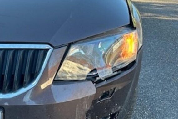 Unfallstelle mit beschädigtem Verkehrszeichen und Fahrzeug, Polizei und Verkehrssicherheit im Fokus.