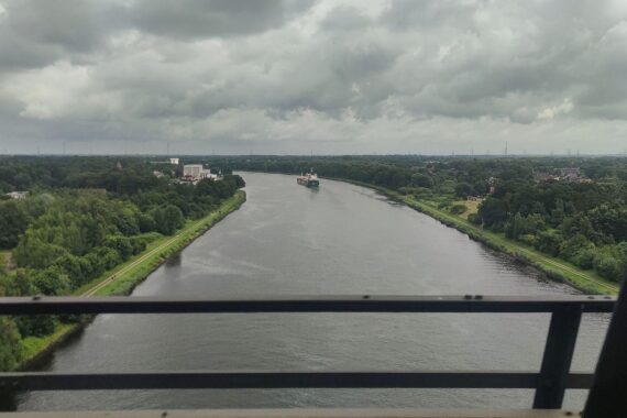 Blick auf den Nord-Ostsee-Kanal: bewölkter Himmel, kühle Temperaturen, ruhige Wasseroberfläche.
