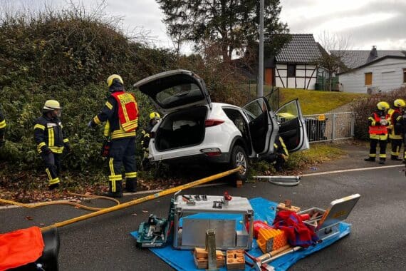 Verkehrsunfall mit verletzten Personen, Feuerwehr im Einsatz, Fahrzeug im Straßengraben, Rettungsaktion.