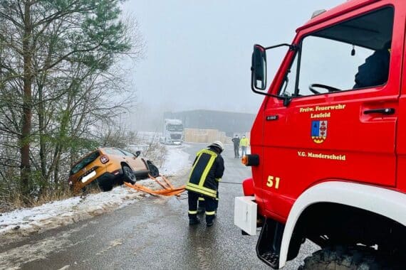 Ein PKW rutscht auf glatter Straße von der Fahrbahn, Winterbedingungen sichtbar.