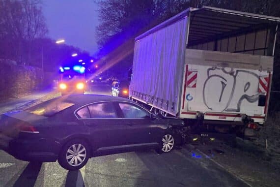 Unfall in Bielefeld: Auto kollidiert mit geparktem Lkw, Fahrer verletzt, hoher Sachschaden.