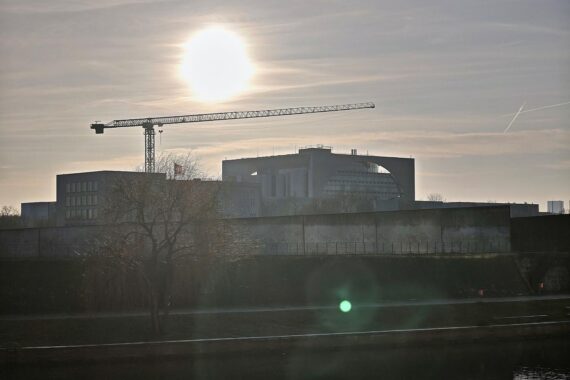 Bundeskanzleramt mit politischen Beamten im Gespräch über Handelsstreit und diplomatische Reaktionen.