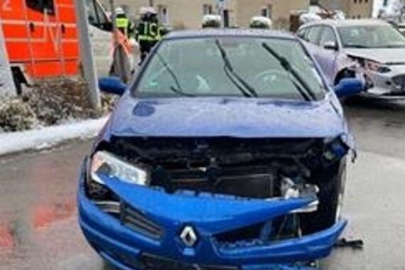 Zwei beschädigte Autos nach Unfall, Rettungswagen vor Ort, Verletzte werden versorgt.